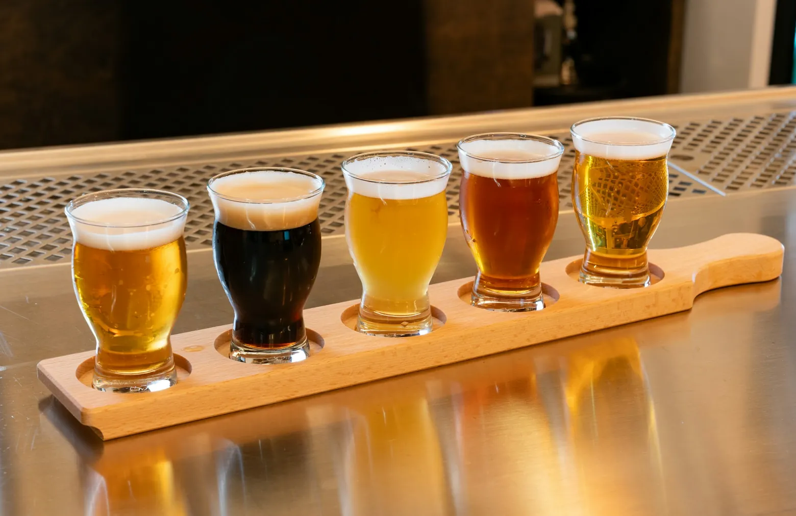 Flight of five craft beers on a wooden paddle